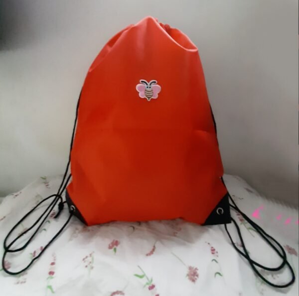 red drawstring bag with pink bee embroidered patch
